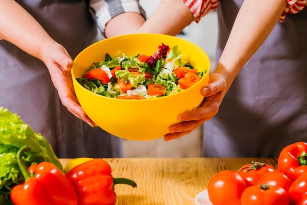 Ręce przygotowujące sałatkę z warzyw